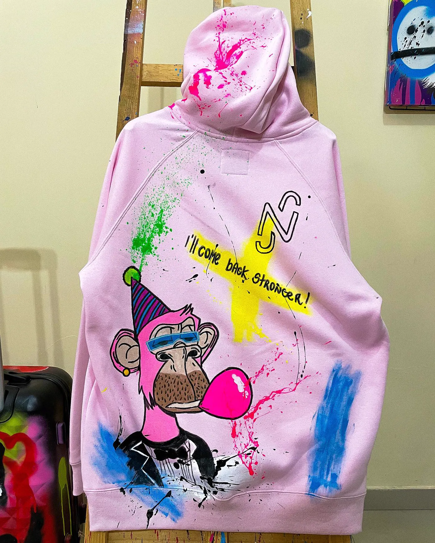 Moletom rosa pintado à mão para Neymar Jr, com o monograma NJR, um macaco de óculos fazendo bola de chiclete e a frase I will come back stronger