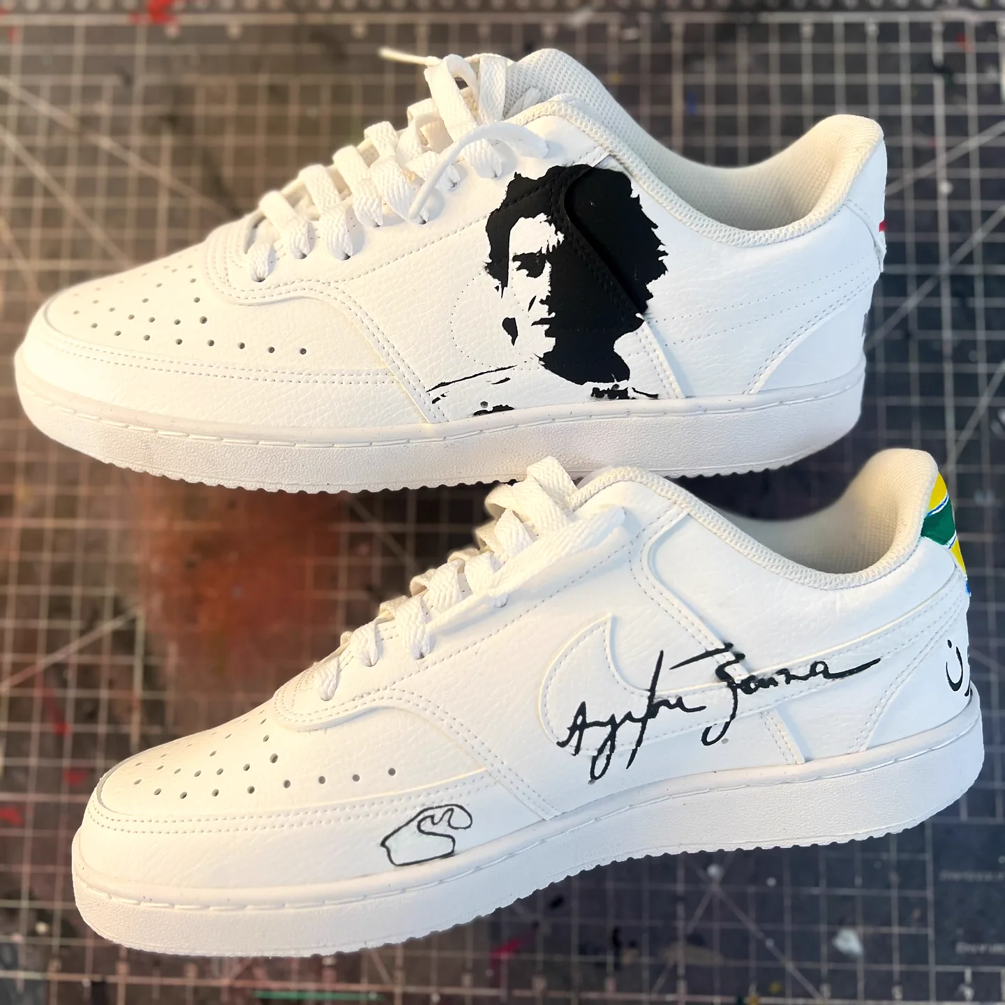 Par de tênis branco com o rosto e a assinatura de Ayrton Senna pintados em preto