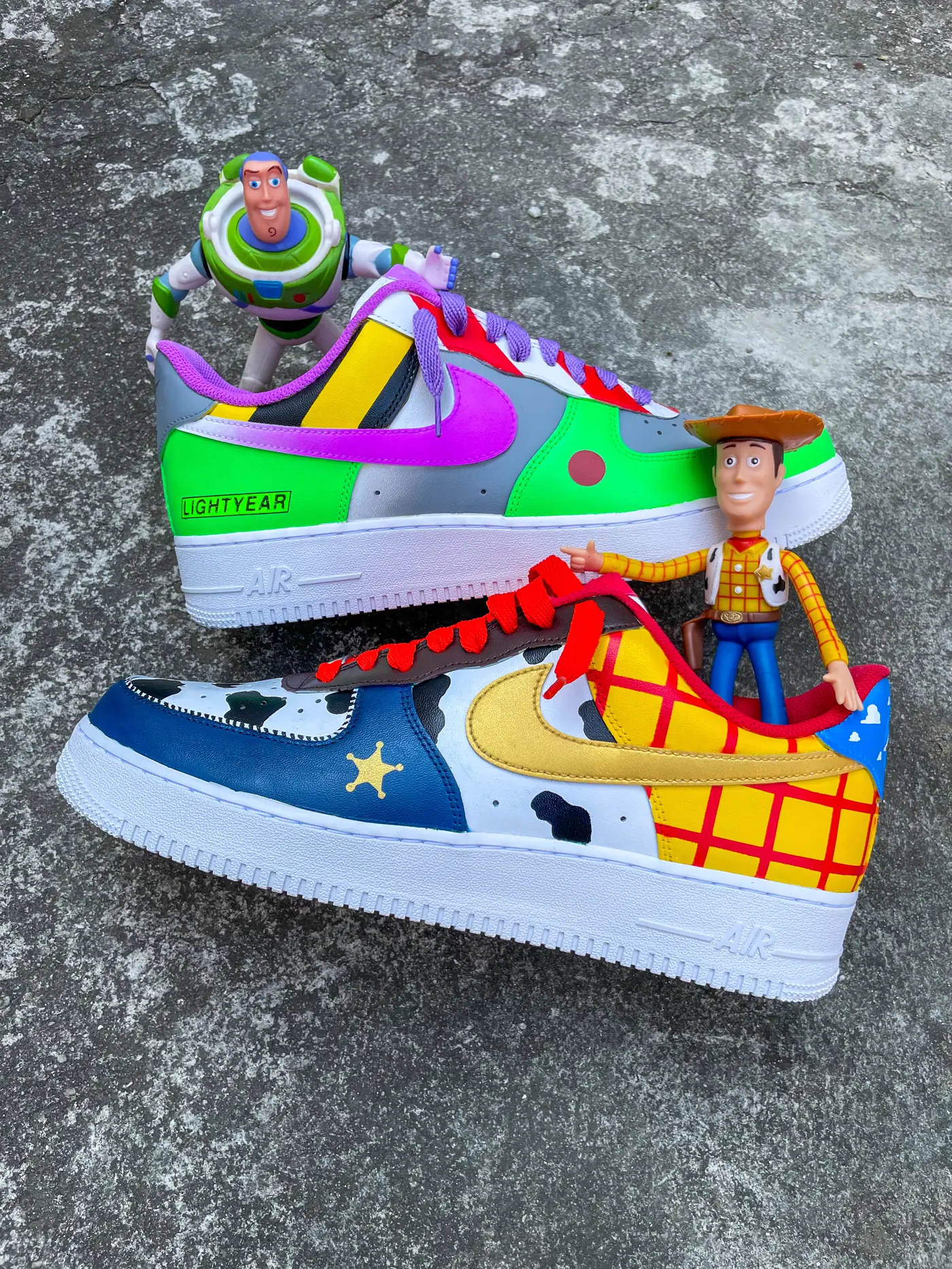 Par de Air Force 1 pintado com Woody e Buzz Lightyear, ao lado dos bonecos de Toy Story